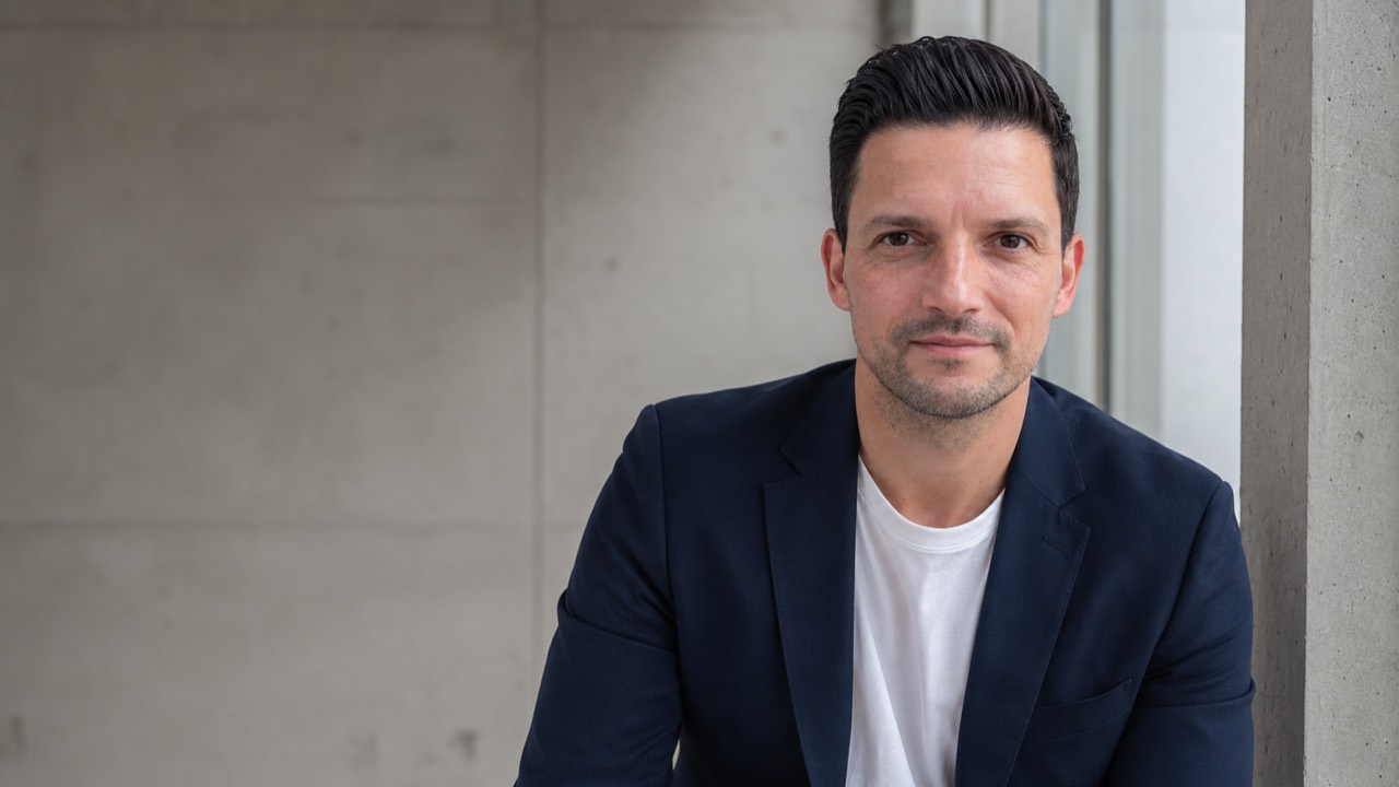 Sebastian Greiber vor reduzierter moderner Betonarchitektur